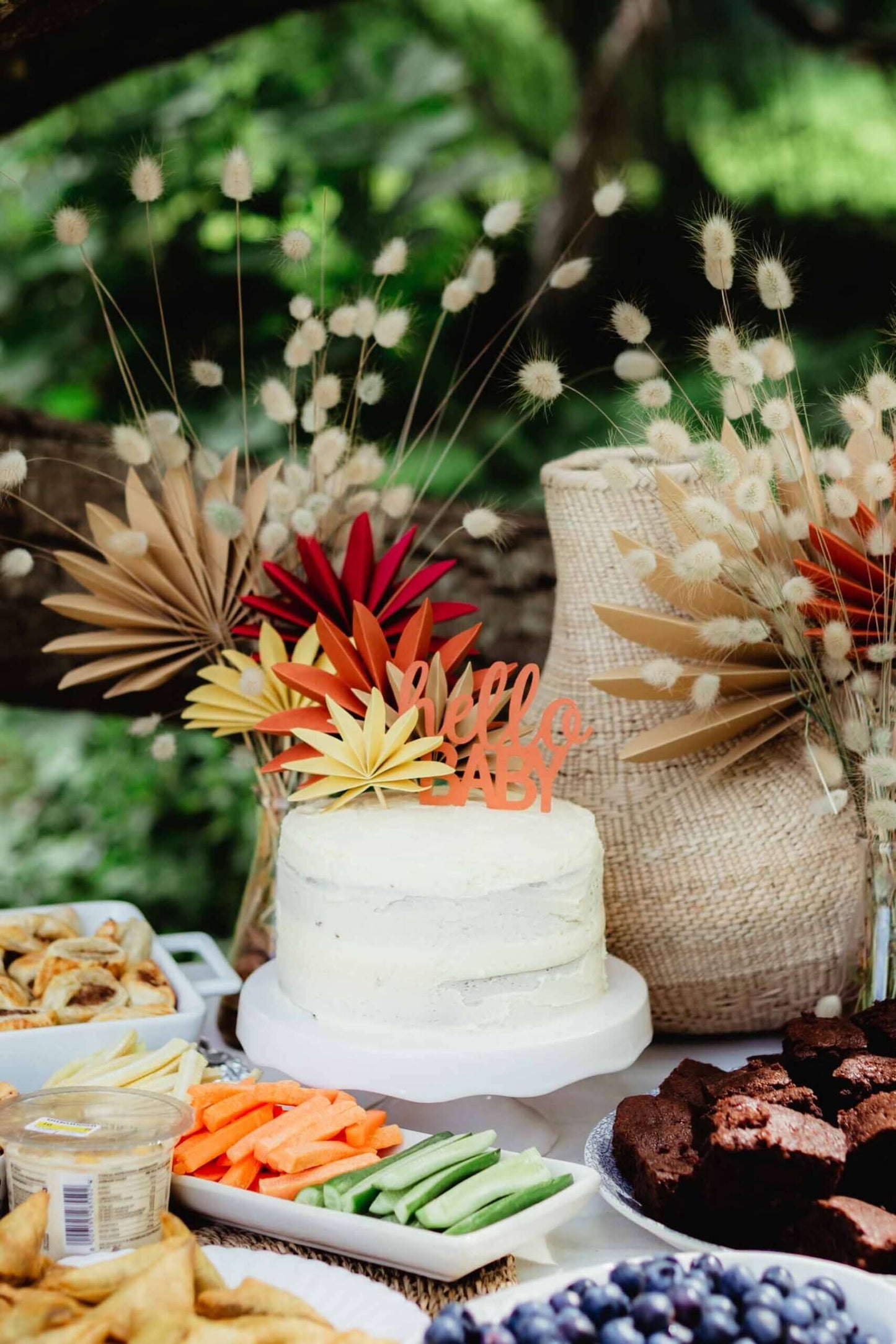 Hello Baby Cake Topper | Boho Baby Shower Decor (DIY) on a decorated dessert table with snacks and flowers.