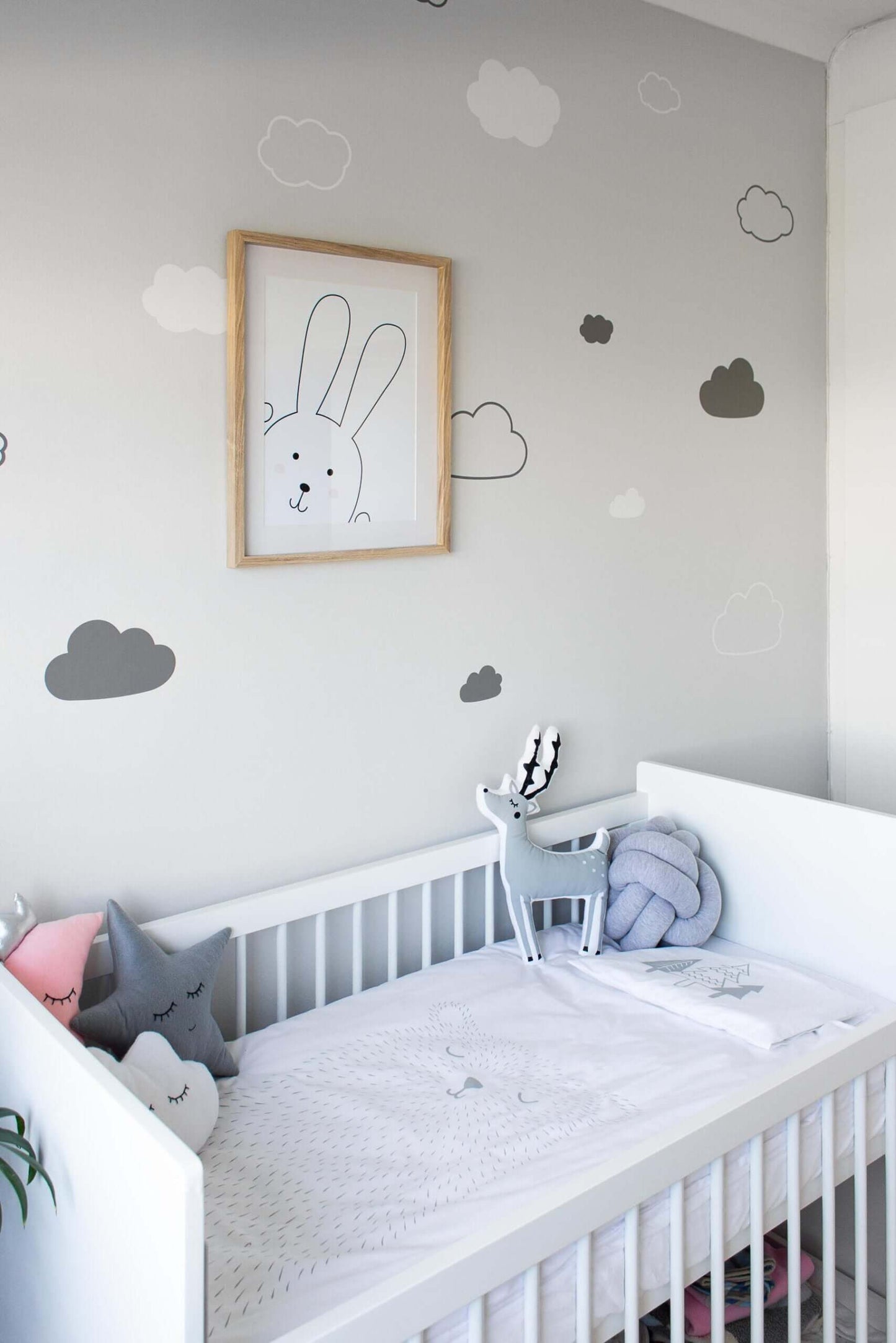 Cloud Wall Decals SVG | Gender Neutral Nursery Decor (Digital Download) in a cozy nursery with a crib.